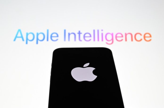 In this photo illustration, the 'Apple' logo is displayed on a mobile phone screen in front of a computer screen displaying Apple Intelligence logo.